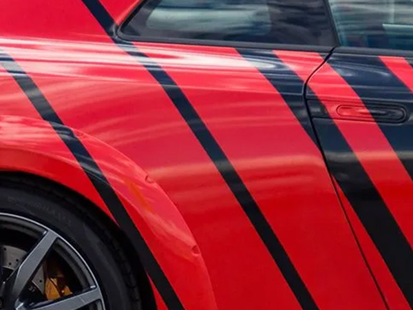 Red car with printed and laminated black wraps on the side